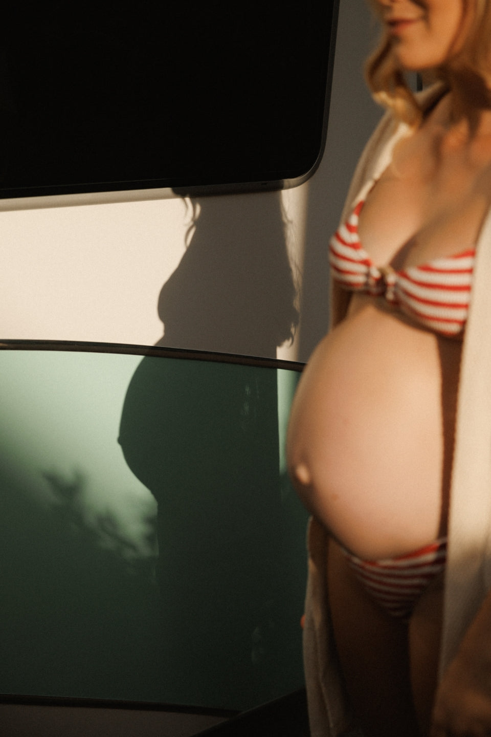 Side profile of a pregnant woman with glowing skin and a gentle expression