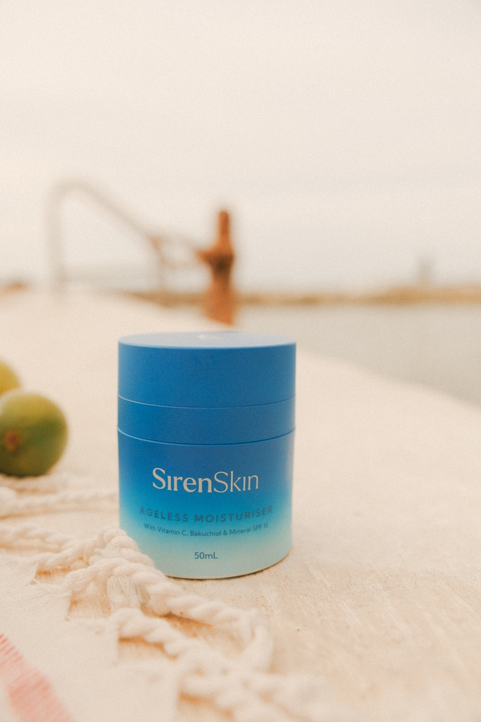 Blue jar of Siren Skin cream on a textured surface with blurred background